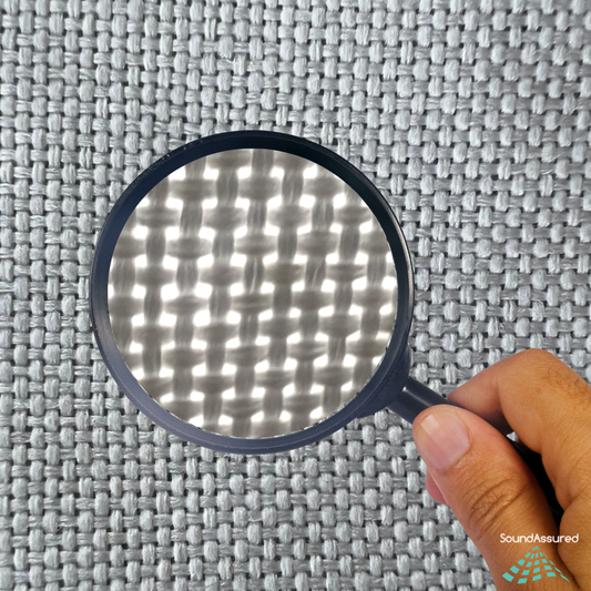 Close-up of acoustically transparent fabric with a magnifying glass showing an open weave that allows sound to pass through for acoustic panels.