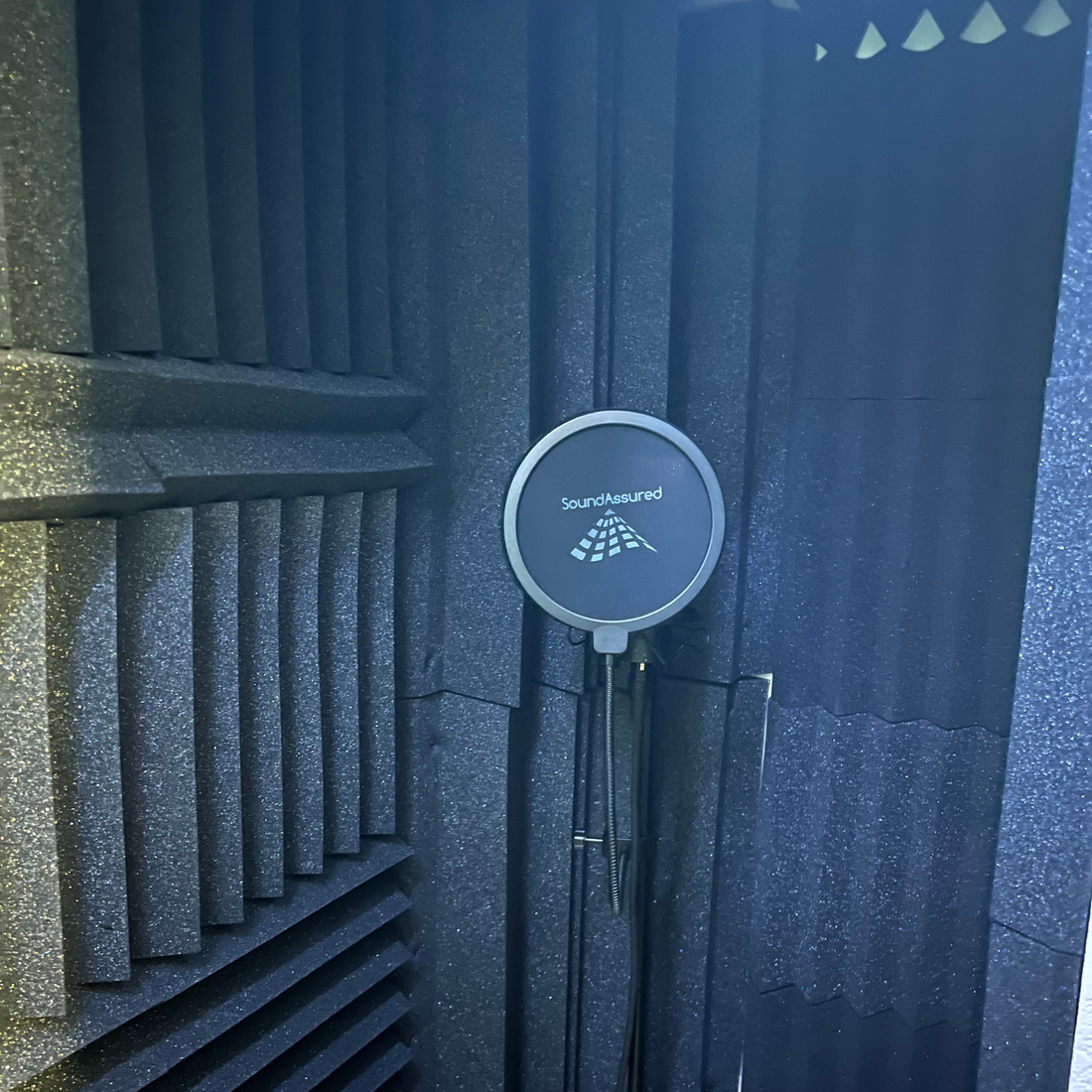 closet vocal booth setup with microphone stand, pop filter, acoustic foam panels, bass traps, and led light strip
