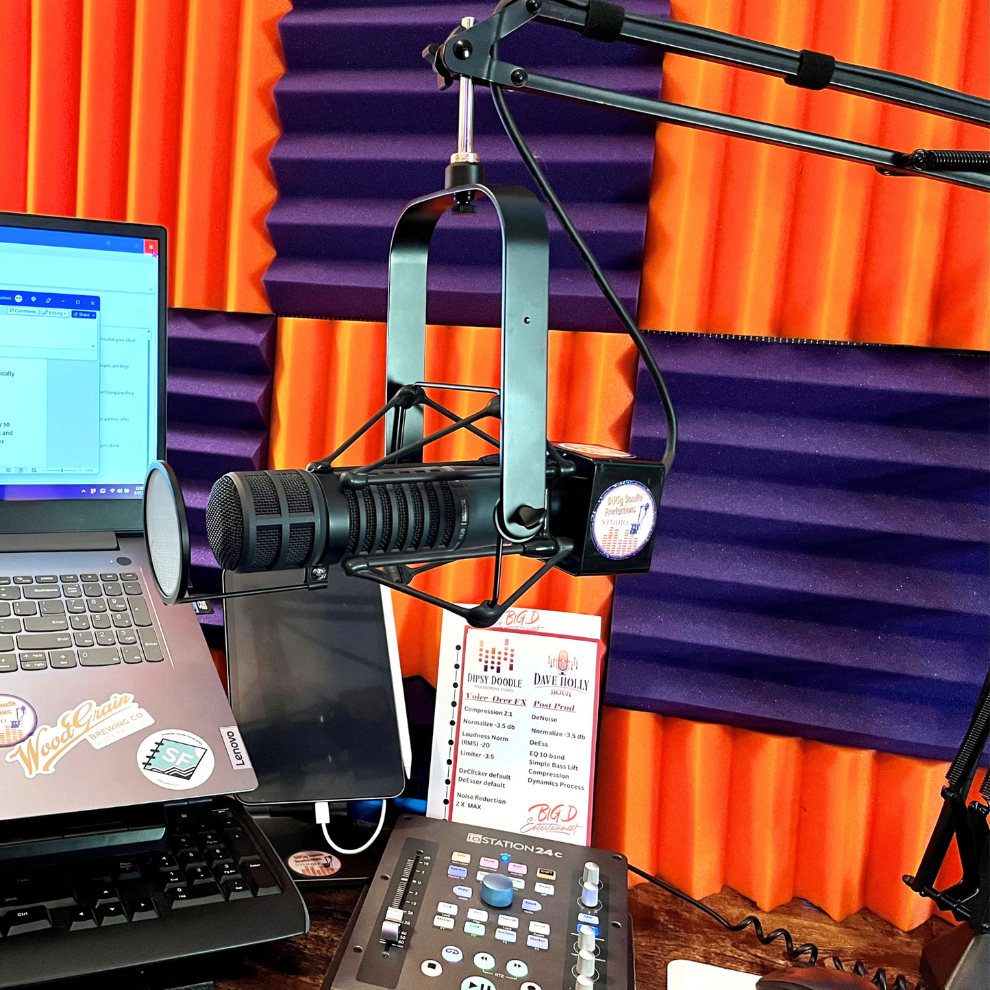 Streaming studio setup with microphone, laptop, and soundproofing panels.
